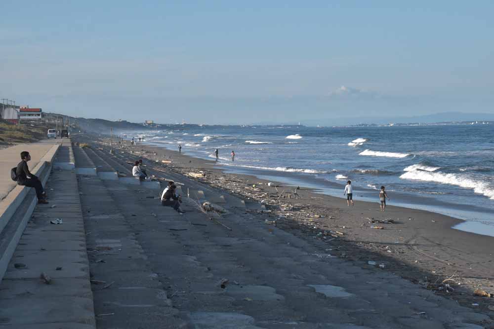 鉾田市の大竹海岸から鹿島灘を望む人々。海岸の先は大洗方面
